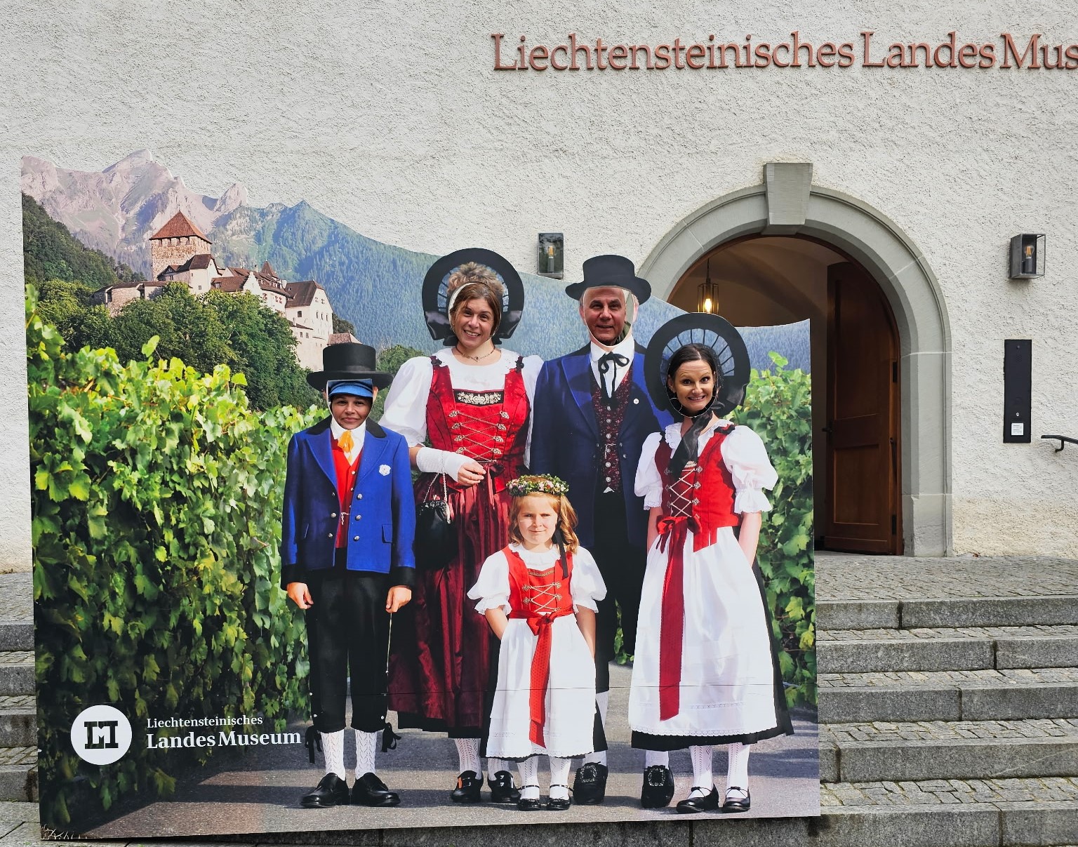Four chaperones of the trip to Europe put their faces in cutouts to have their photo taken outside of a museum.
